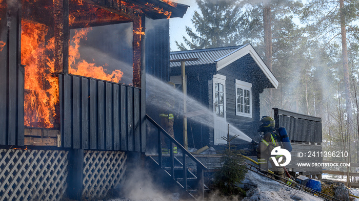 Firefighters trying to put out flames cabin on fire