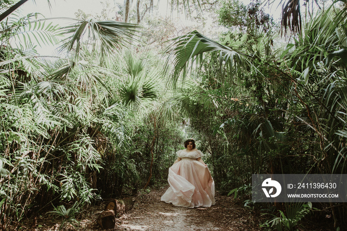 plus size woman walks in forest wearing a big dress