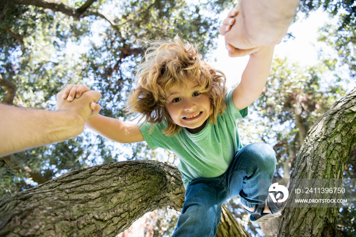 Father helping son. Fathers hand and helping son to climb tree. Child protection.