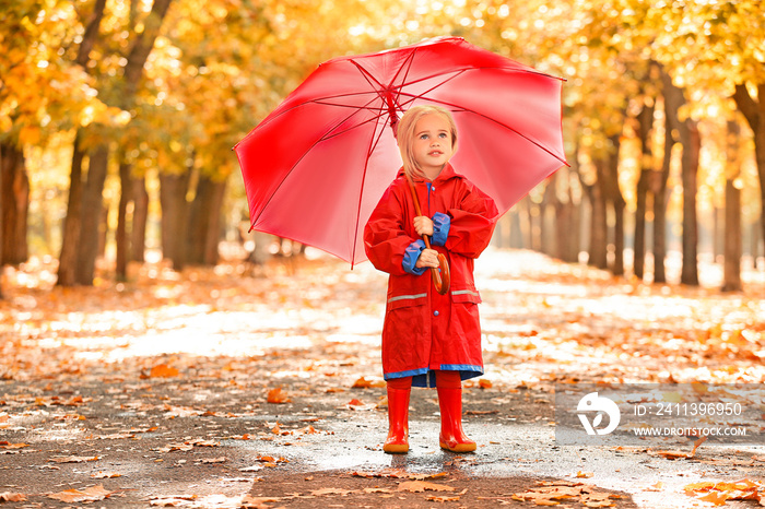 Cute little girl with umbrella in autumn park