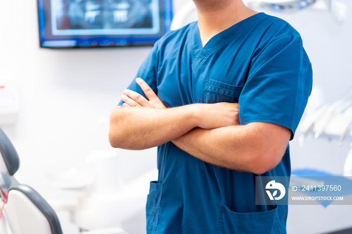 Dental clinic, unrecognizable caucasian male dentist with arms crossed