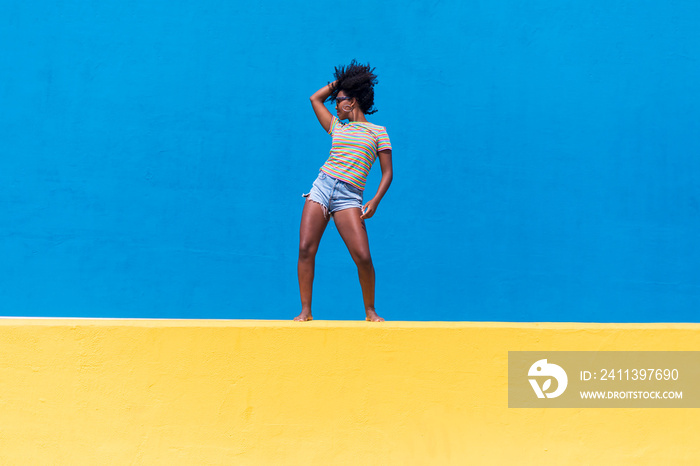 fun young afro american woman laughing and dancing outdoors