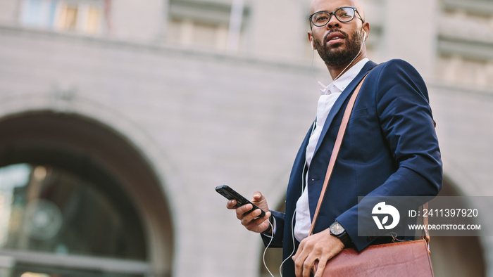 African businessman walking on city street