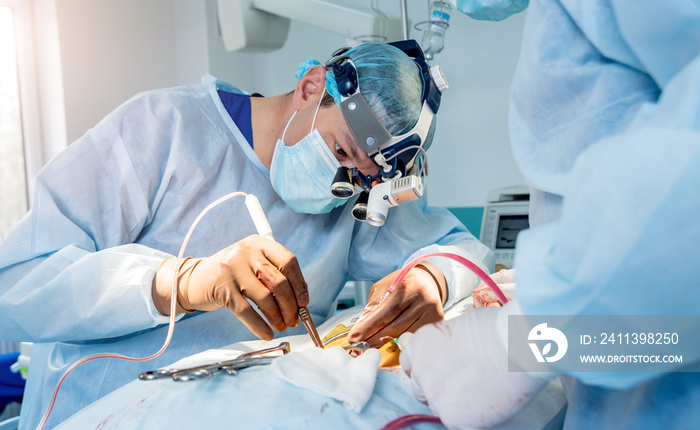 Spinal surgery. Group of surgeons in operating room with surgery equipment. Laminectomy