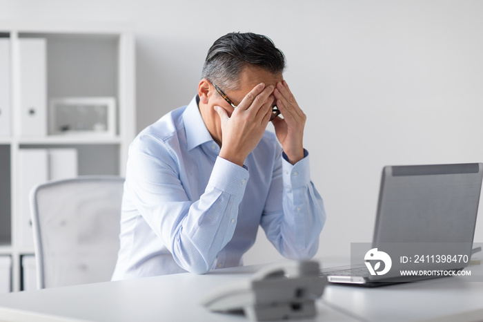 business, deadline and stress people concept - stressed businessman with laptop working at office