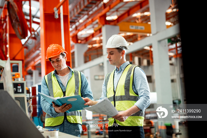 Engineer protective clothing in factory young electrical engineer woman using touchpad with digital tablet and standing and talking in control room factory