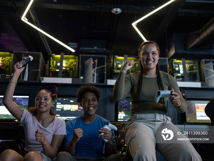 Smiling friends playing video games in gaming club