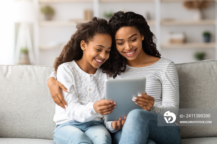 Happy african american mother and kid using digital tablet together