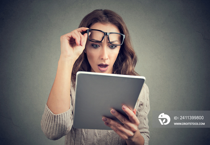 Woman with tablet looking shocked