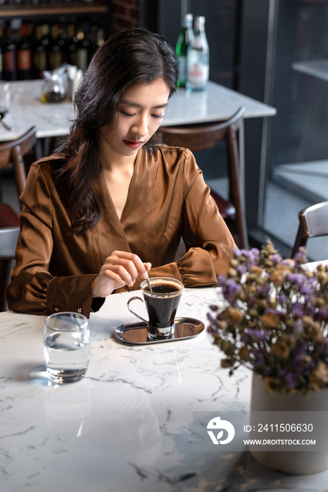 漂亮的青年女人喝咖啡