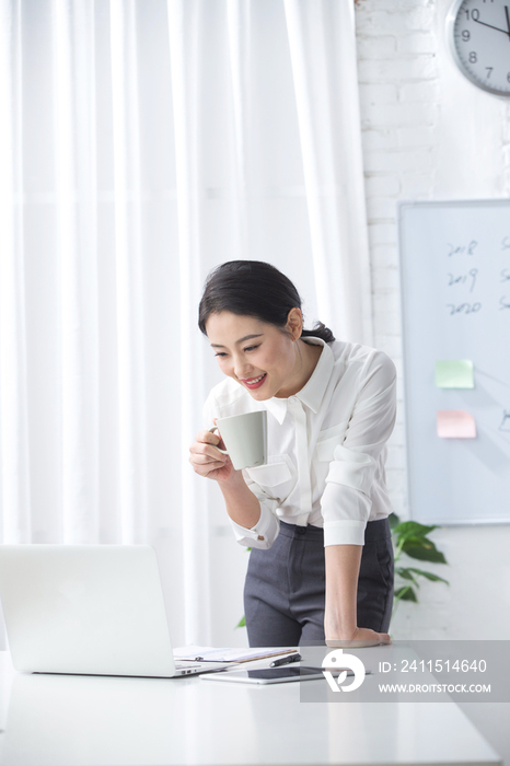 青年商务女人使用笔记本电脑办公