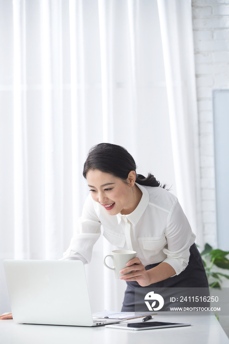 青年商务女人使用笔记本电脑办公