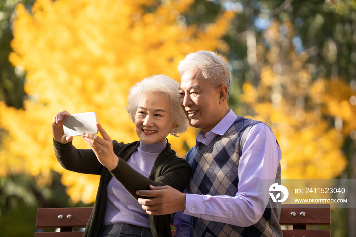 老年夫妇使用手机拍照