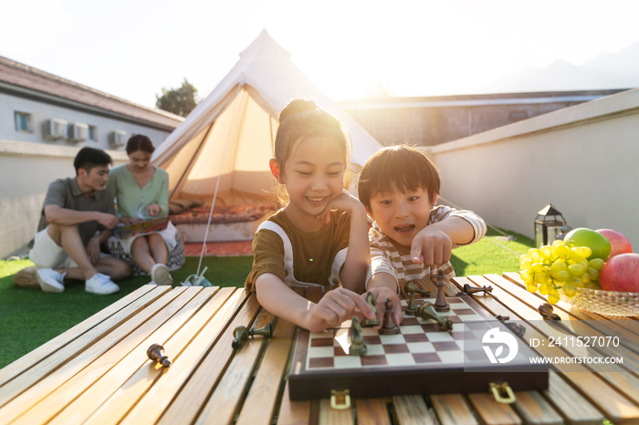 在户外露营的快乐儿童下国际象棋