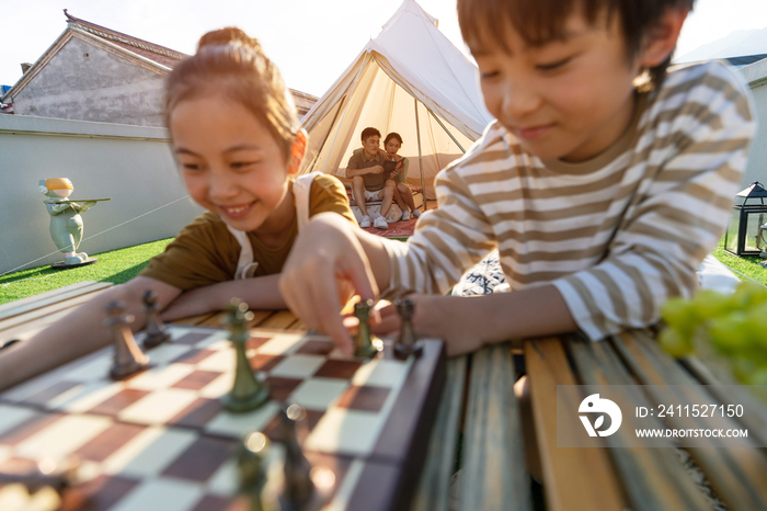 在户外露营的快乐儿童下国际象棋