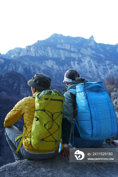 青年登山者伴侣坐在岩石上