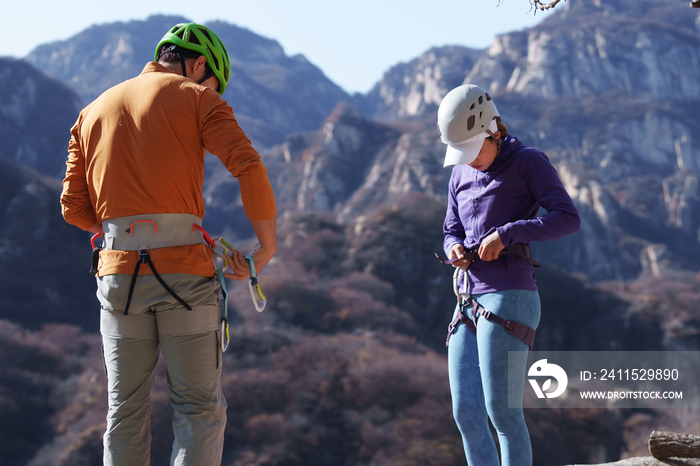 青年登山者伴侣调整登山设备