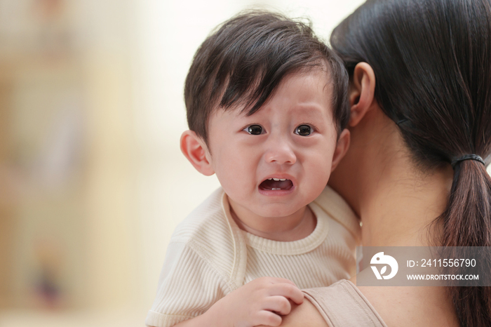 年轻妈妈抱着哭闹的宝宝