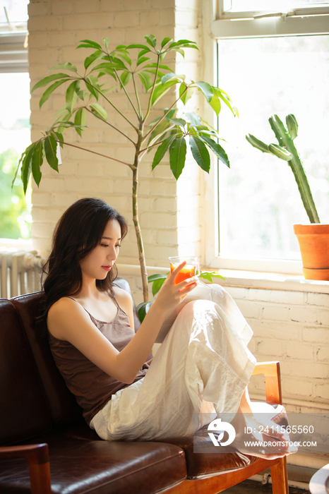 年轻女人在家喝茶看书