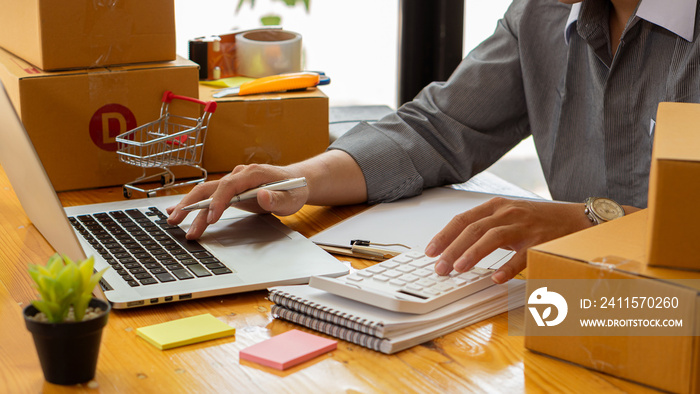 Small business owners working with laptops and telephones, mobile and cardboard boxes at work, small