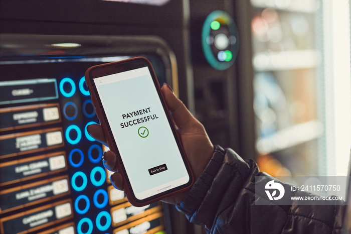 Consumer paying for product at vending machine using contactless method of payment with mobile phone