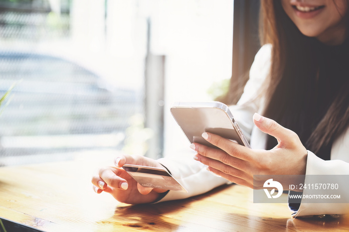 Asian young woman using a mobile phone and credit card for online shopping