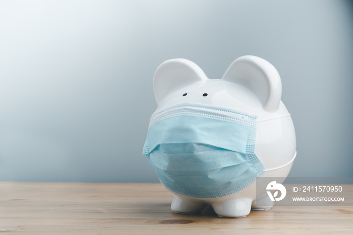 Piggy bank wearing surgical face mask. Global economy during coronavirus pandemic.  Financial crisis