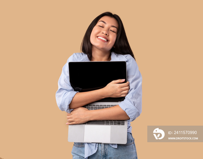 Technology Lover. Excited asian woman hugging personal computer