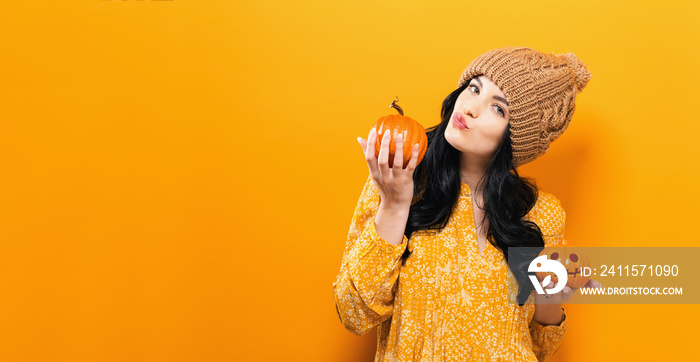 Young woman holding a pumpkin in halloween theme