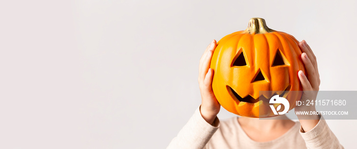 Woman holding decorative pumpkin instead of head over gray