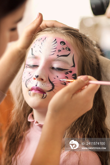 Cute makeup little tiger. face painting outdoors, having fun, copy space. girl with aqua makeup of t