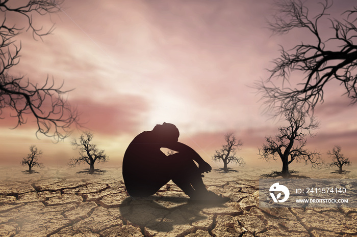 People sit with their heads down and hopeful in a dry land because of the drought there is no rain f