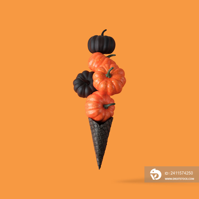 Black ice cream cone with autumn pumpkins. Halloween minimal concept.