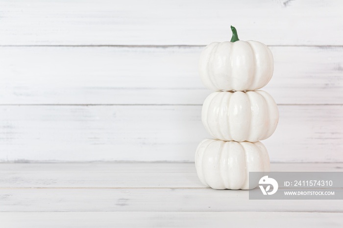 Stack of white pumpkin on white wood table with copy space.