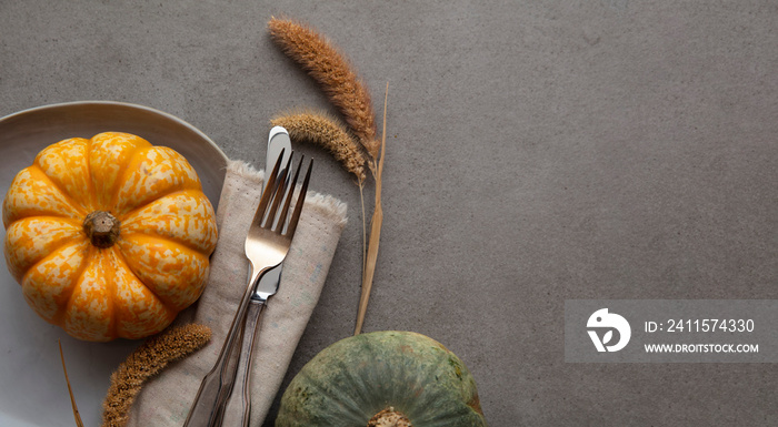 Autumn place setting lifestyle thanksgiving background with cutlery and pumpkins