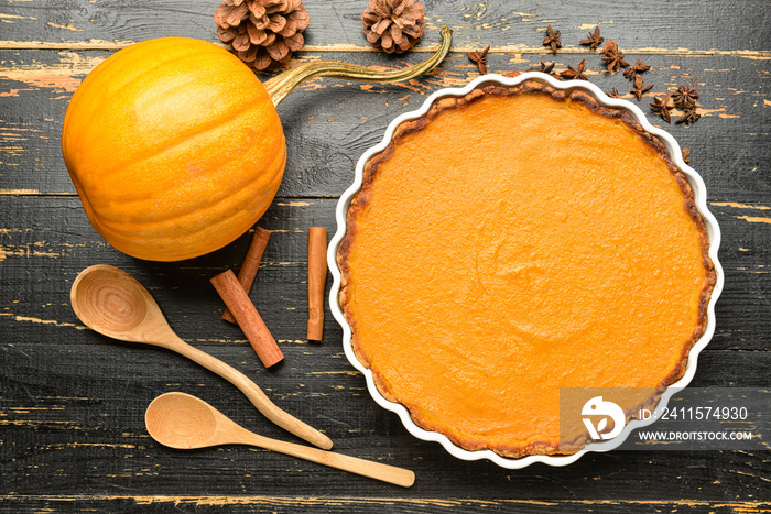 Composition with delicious pumpkin pie on black wooden background