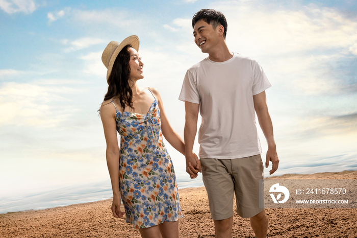 幸福的年轻伴侣在海滩上散步
