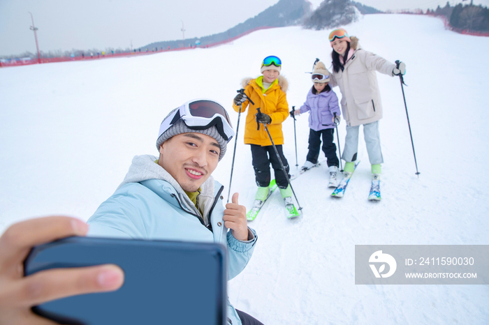 滑雪场上用手机自拍的一家四口