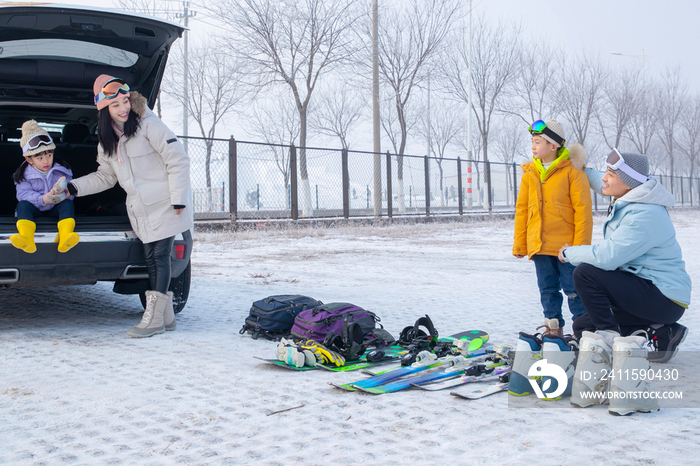 停车场内清点滑雪装备的一家四口