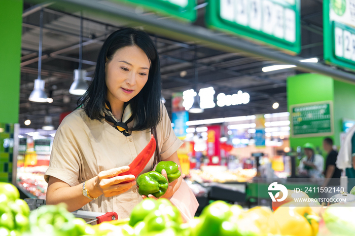 中年女性在超市挑选蔬菜