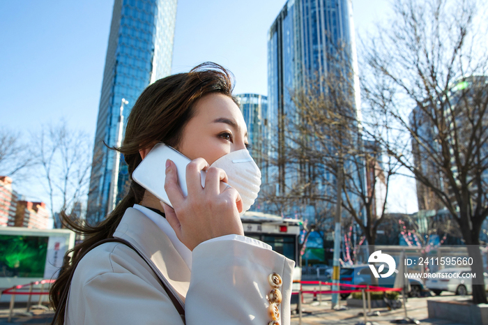 戴口罩的青年女人打电话