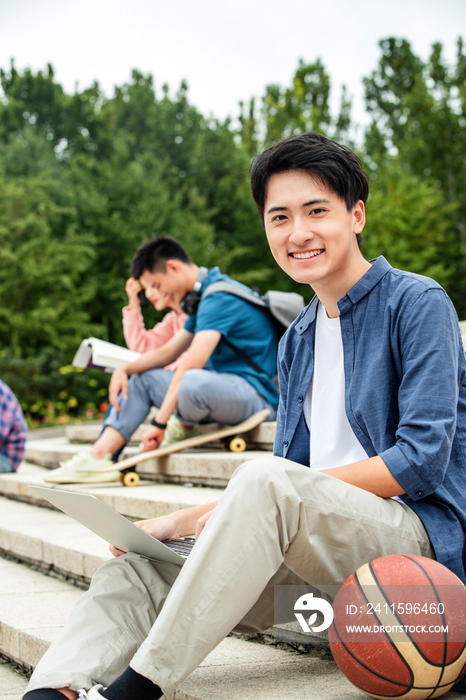 快乐的大学生坐在台阶上学习