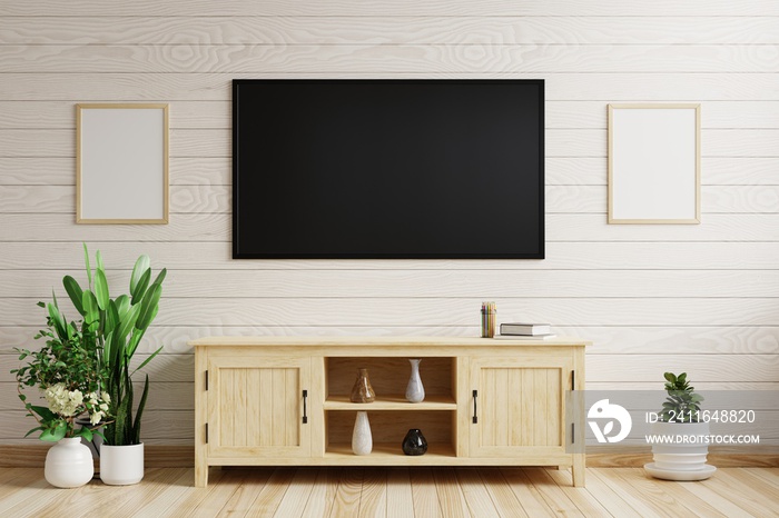 Tv on the white wooden wall In the living room decorated with wooden cabinets and plant pots on the 