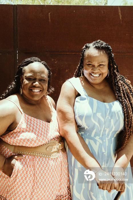 2 African American women stand outside smiling