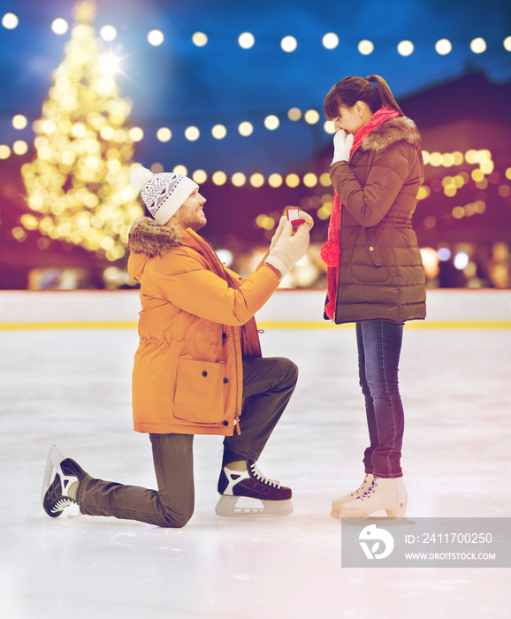 couple with engagement ring at xmas skating rink