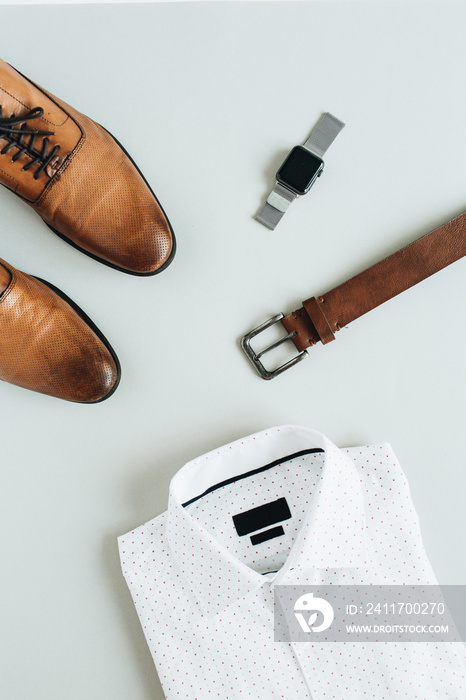 Men’s fashion composition with watch, shirt, belt and shoes. Flat lay, top view.
