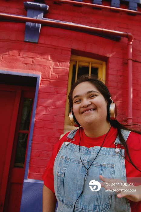 Happy young woman with Down Syndrome listening to music in the city