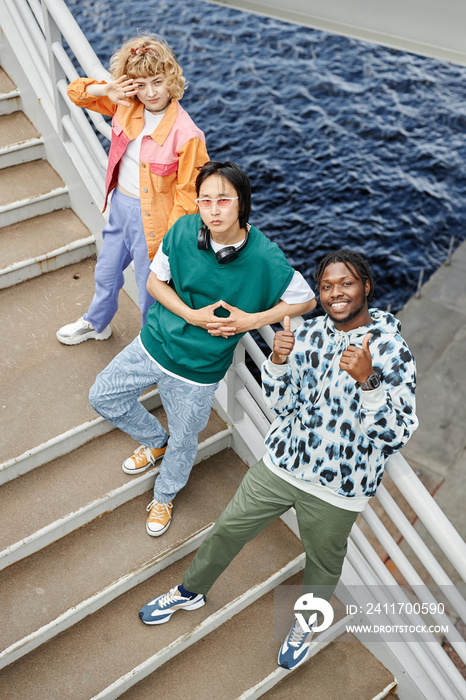 Graphic top view of diverse young people on stairs looking up with water in background