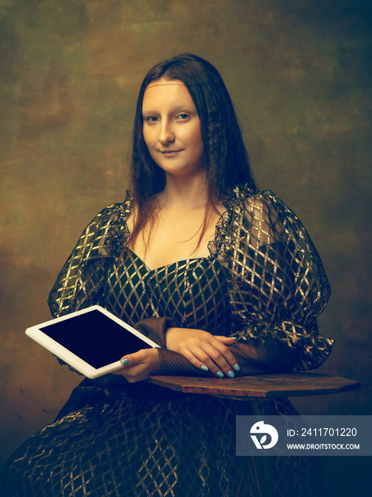 Tablet scrolling. Young woman as Mona Lisa, La Gioconda isolated on dark green background. Retro style, comparison of eras concept. Beautiful female model like classic historical character, old