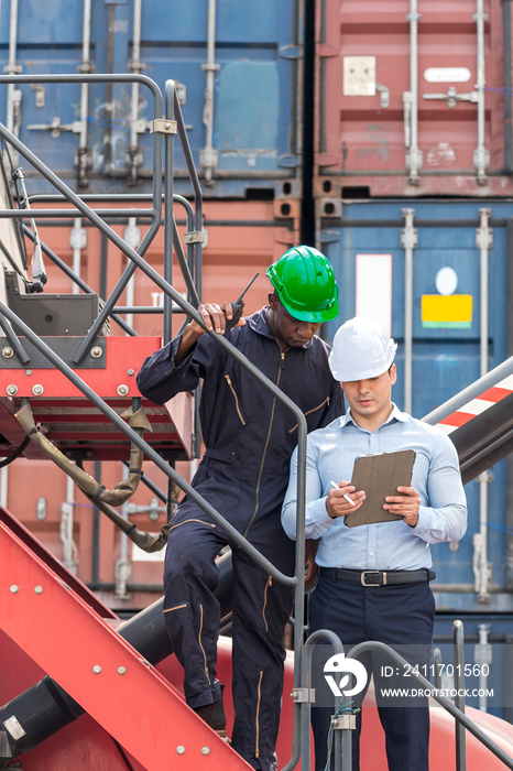 African American Environment engineer and young businessman working and discussing  in shipping container in commercial transport port